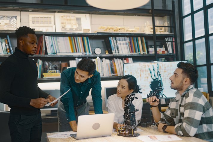 A group discussing development strategies for a robotic hand.