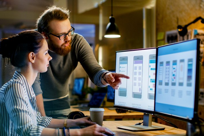 A female UX Designer and male Design Engineer discuss the development of a mobile application.