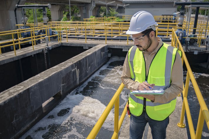An engineer surveys a facility, they are wearing a hi-vis.
