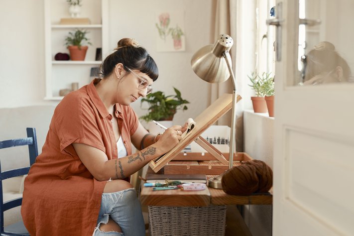 A young female designer draws at her workstation.