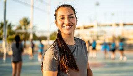 Young woman standing on a netball court