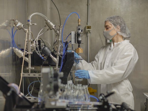 A sterilising technician cleans equipment in a laboratory.