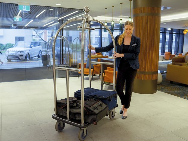 A female pushes a luggage trolley.