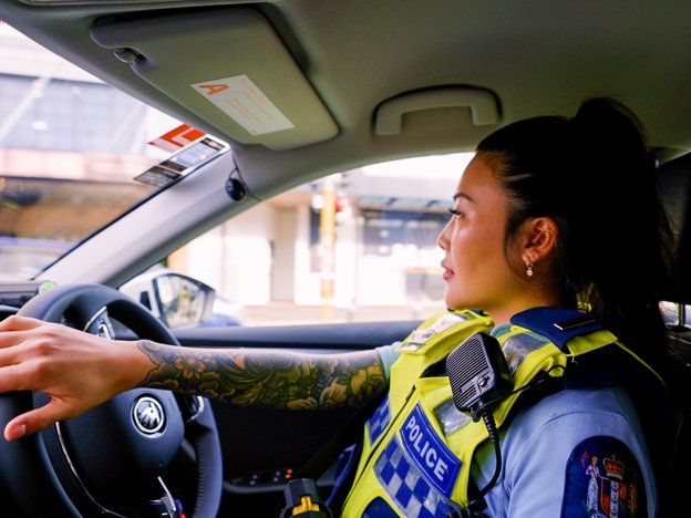 A female police officer driving a police car