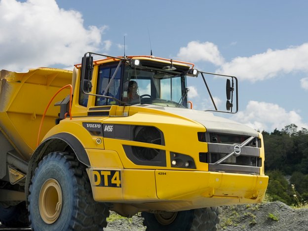 A woman sits in a large yellow quarry.