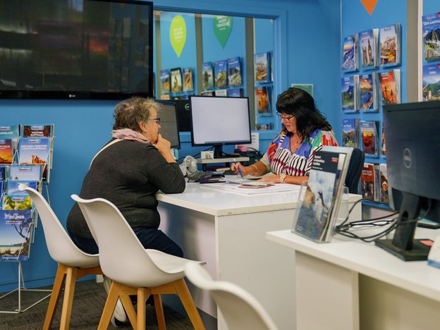 A travel agent is speaking to a client in their office.